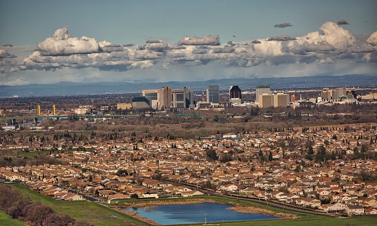 Miles of rooftops in Sacramento with the downtown skyline on the horizon
